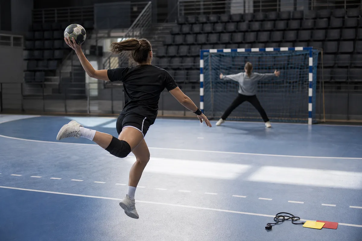 Joueuse de handball tirant un jet de sept mètres face au gardien